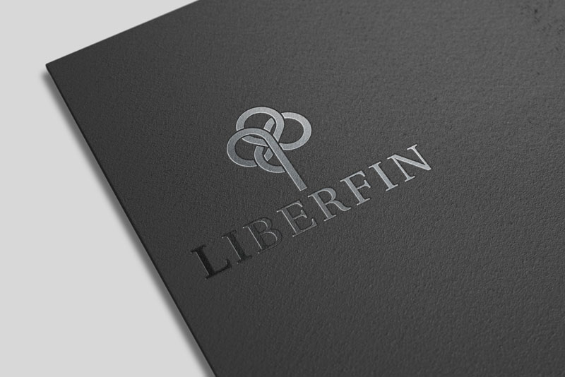 In the picture we see the corner of a black business folder laid on a white background. The logo of the Liberfin company is printed on the map in glossy black.