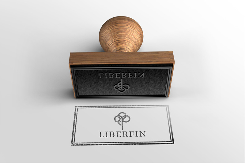 In the picture we see a seal with the logo of the Liberfin company printed in black ink and a laid wooden stamp.