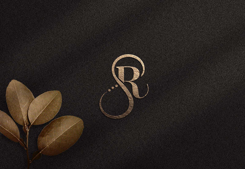 Creating and designing a logo for Villa Sunray The picture shows the logo icon, the monogram of the letters S and R in gold on a black background, with a golden flower in the lower left corner.