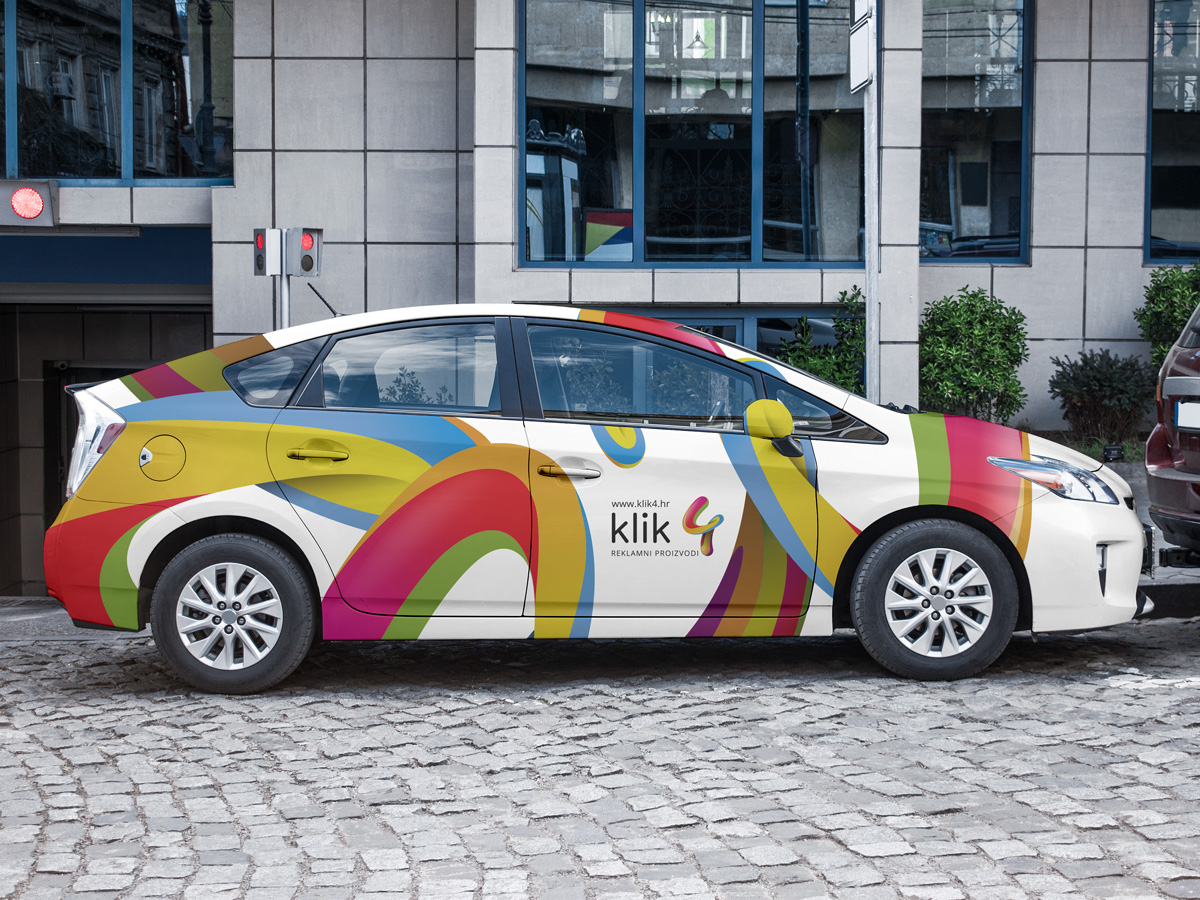 Vehicle Wrap Design for Klik4. The picture shows a painted vehicle, the design is colorful, similar to the colors of the rainbow that stretch along the entire length of the vehicle.