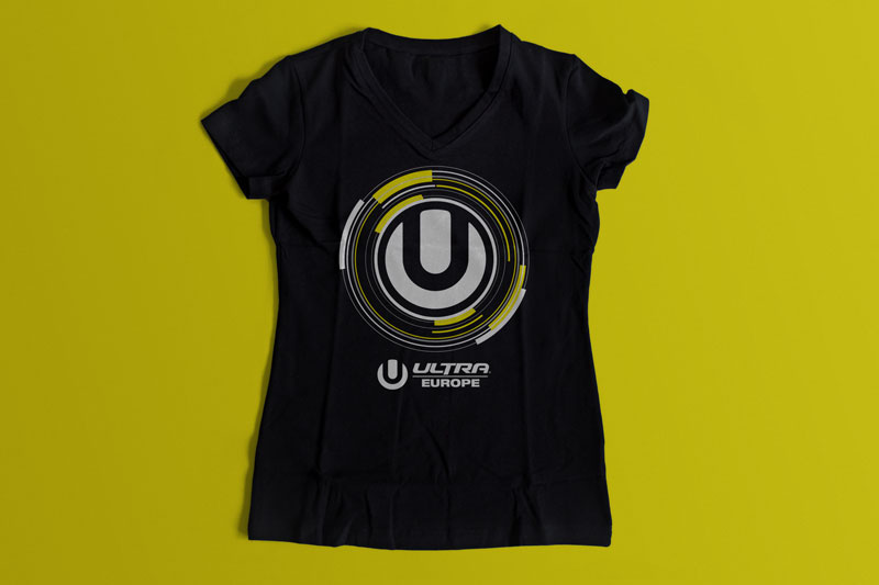 T-shirt design for the Ultra Europe music festival held in Split, Croatia. In the picture we see a black women's T-shirt on a mustard yellow background. The T-shirt features a design (the letter U inside a yellow-white circle) and the logo of the Ultra Europe festival.