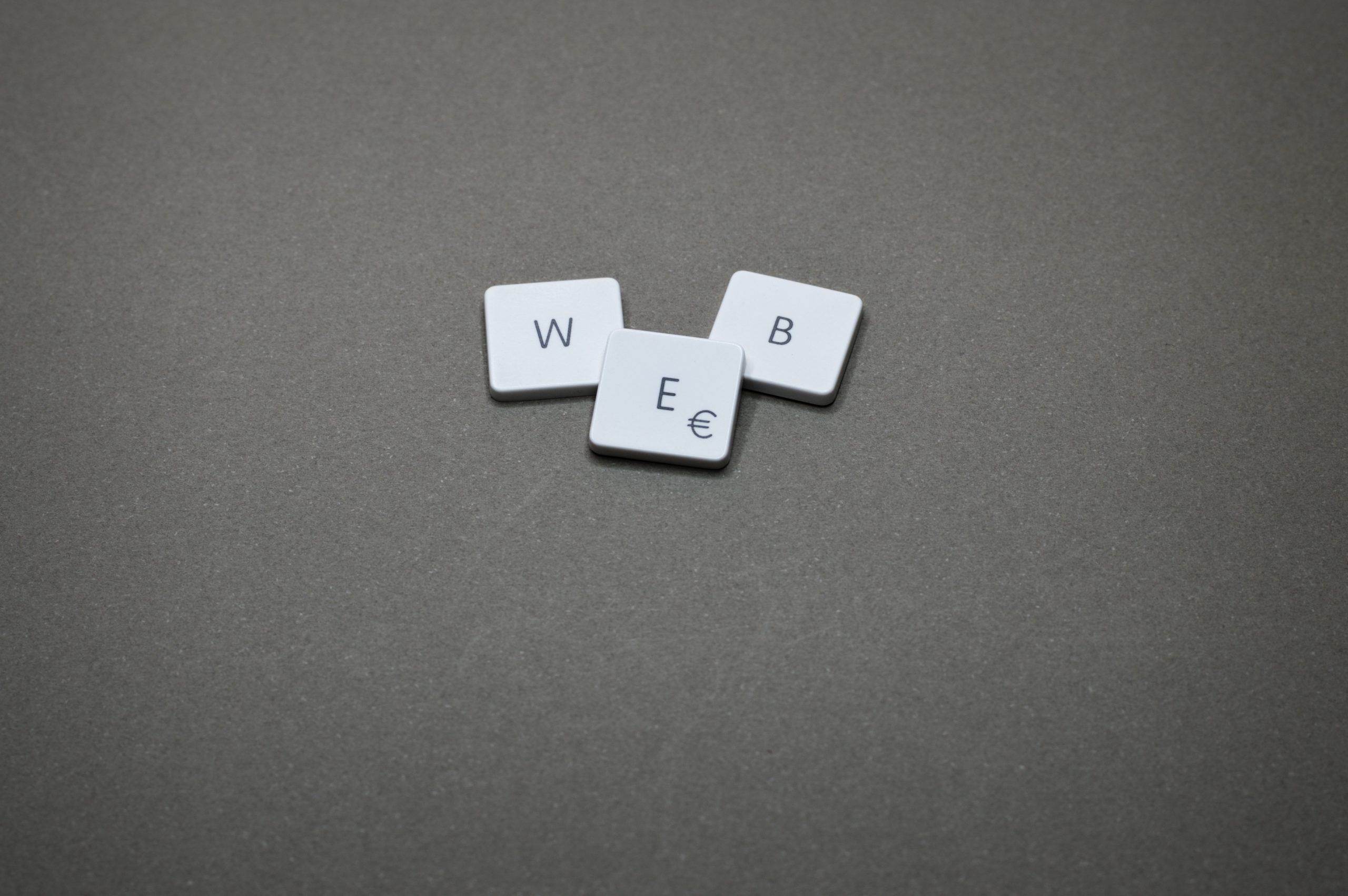 Blog o izradi i dizajnu web stranica: slika prikazuje slova tipkovnice: w, e i b na sivoj podlozi
