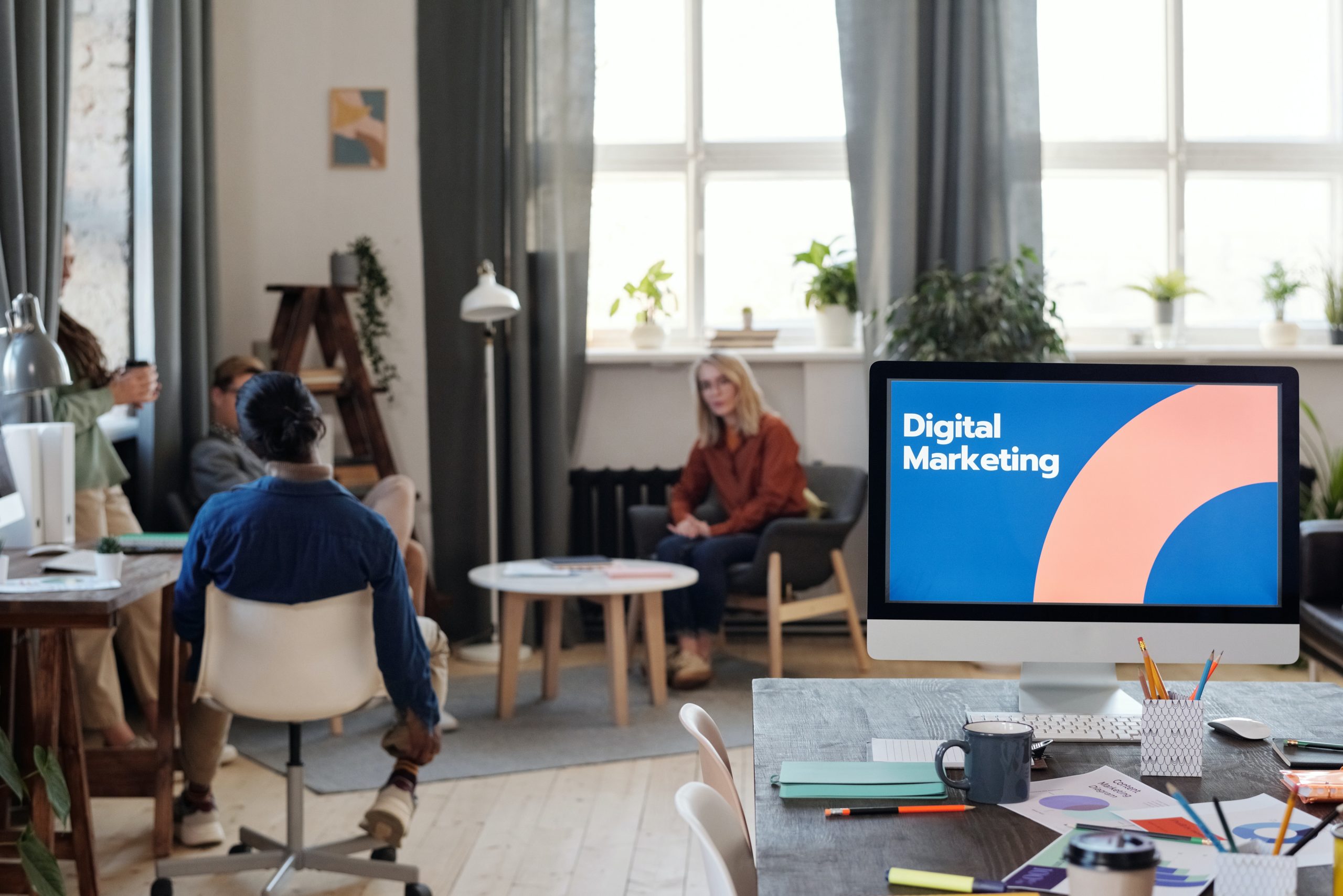 Digital marketing blog: the picture shows an office with people and a lit computer monitor with the words digital marketing on it