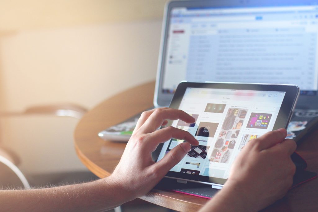 blog about running social networks: the picture shows a person working on a tablet with a monitor lit in the background