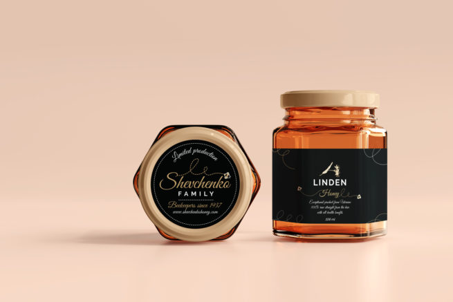 Dizajn etikete za med za Shevchenko obitelj. Na slici je teglica meda sa crnom etiketom. druga teglica je položena na stranu i vidimo etiketu na poklopcu.