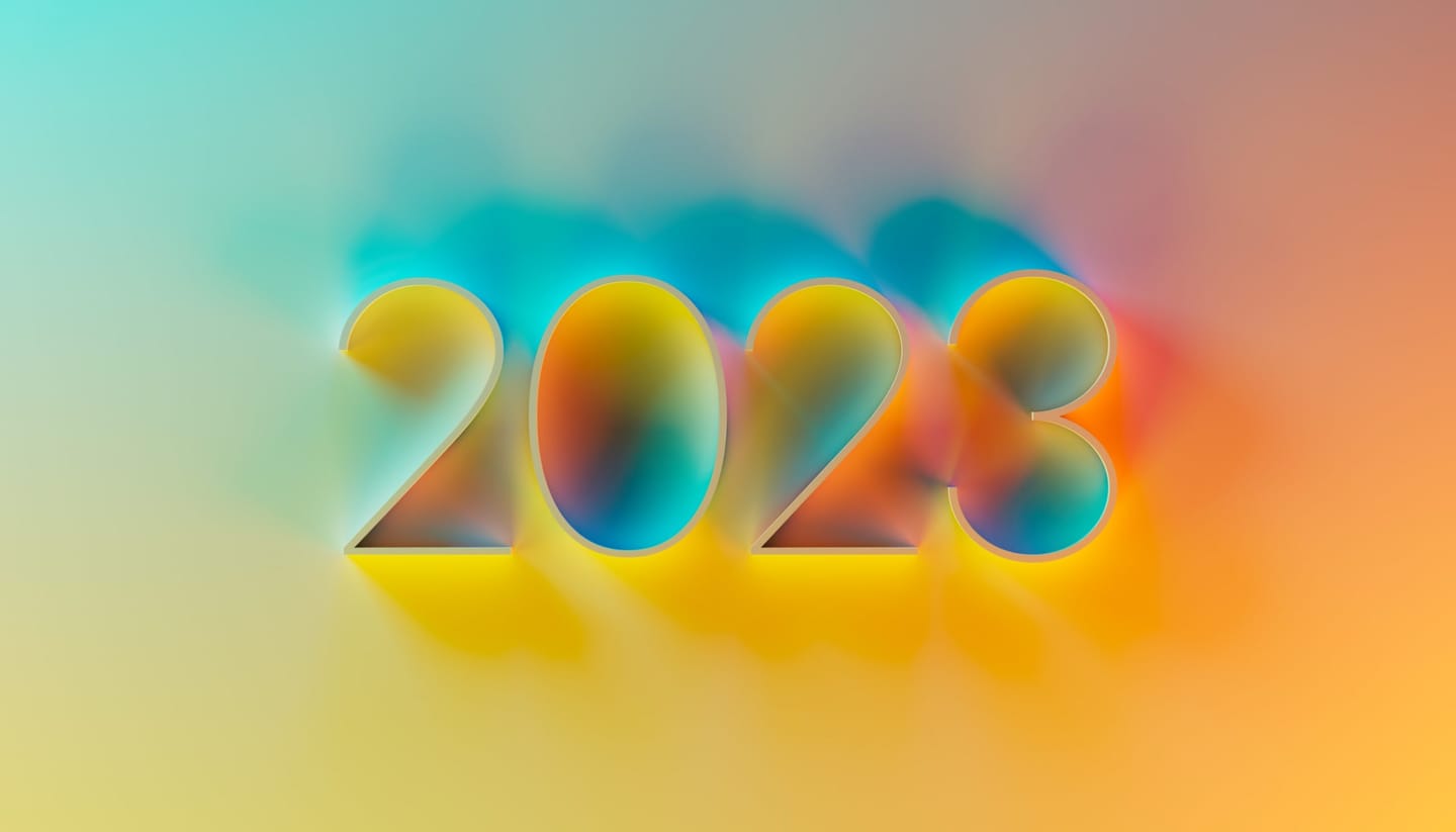 Broj 2023 ispisan prozirnim trodimenzionalnim znamenkama na nježnom prijelazu tirkizne, žute i narančaste boje