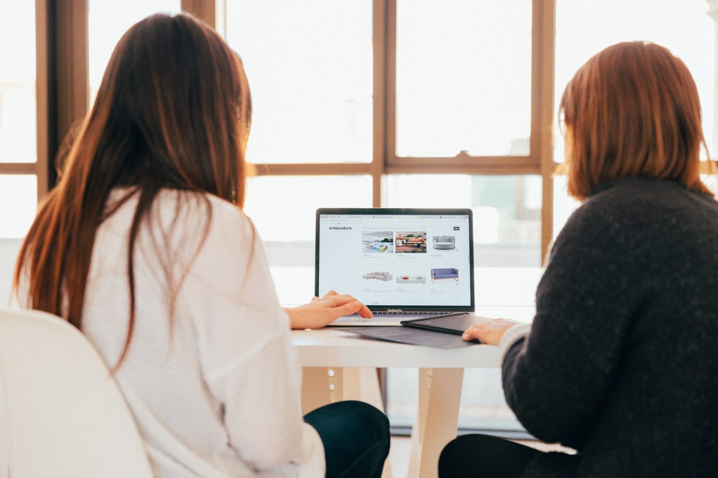 Two people reviewing a website together on a laptop
