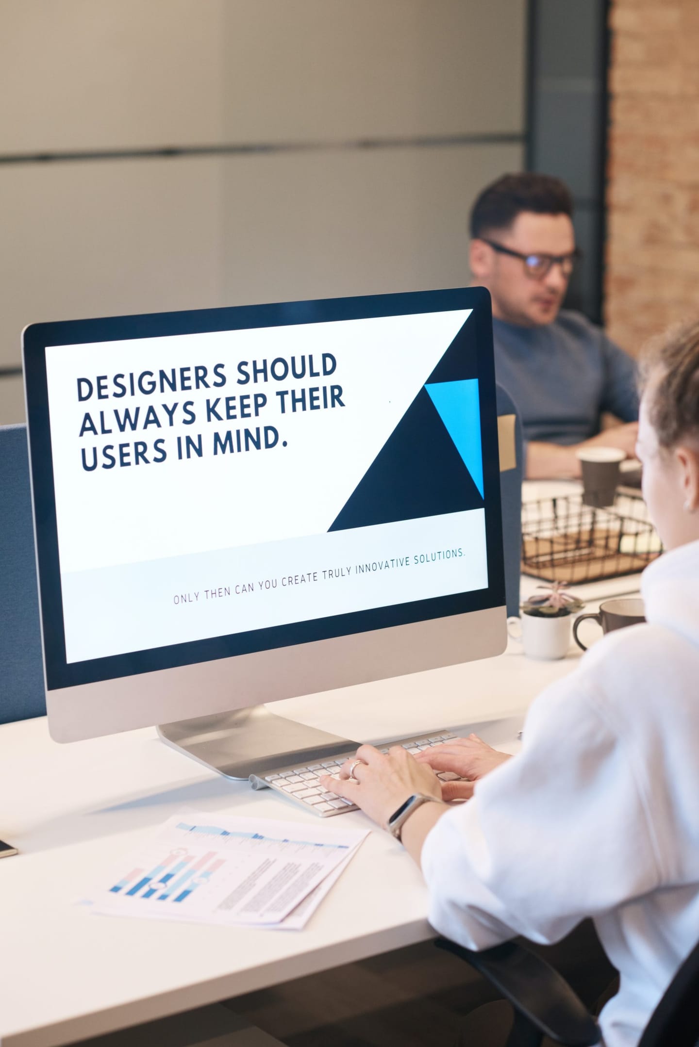 Blog about ux and ui design: the picture shows a monitor on a desk in an office. on the monitor it says: designers should always keep their users in mind.