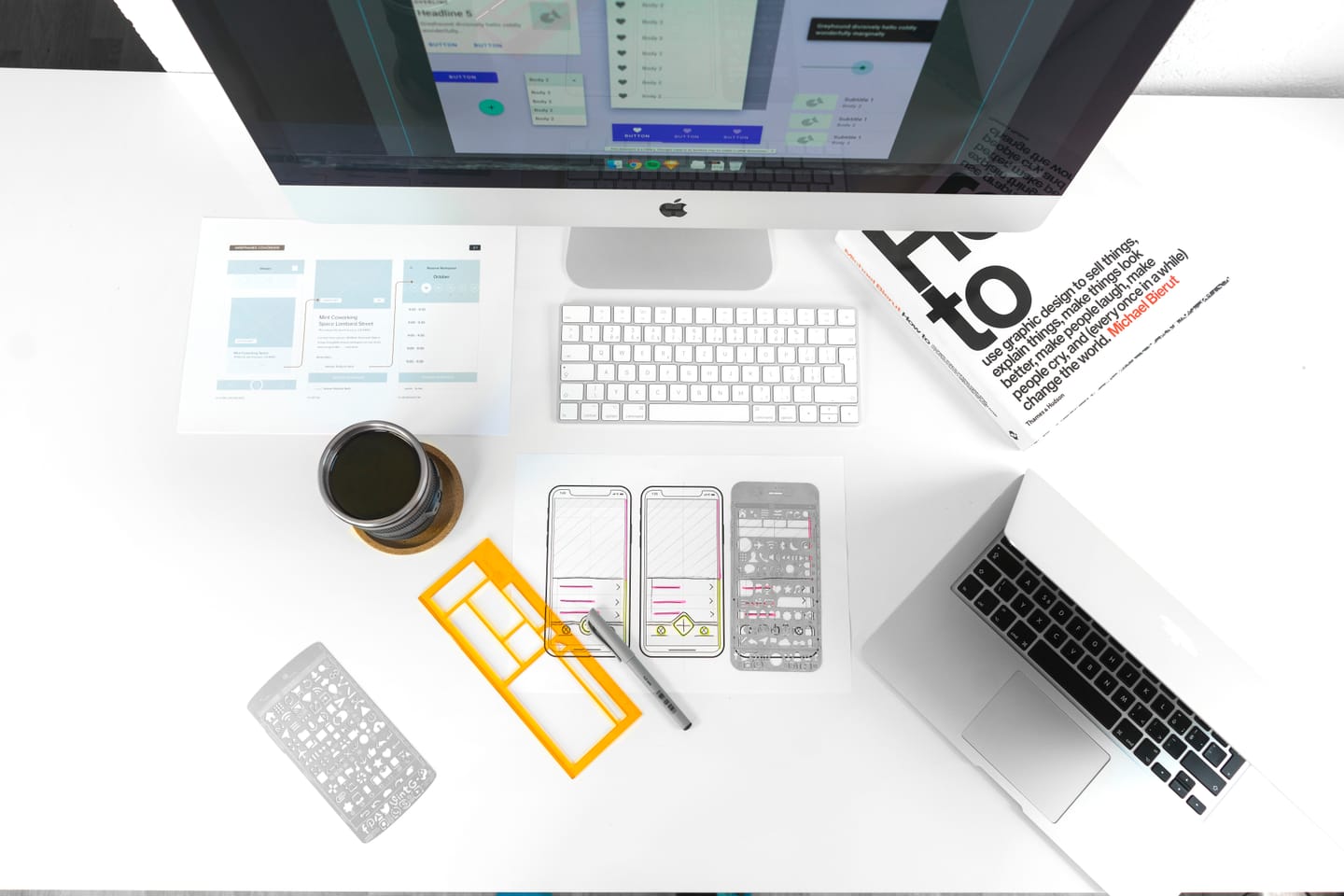 Blog about UX and UI design: a desk with UX design papers and a monitor on it