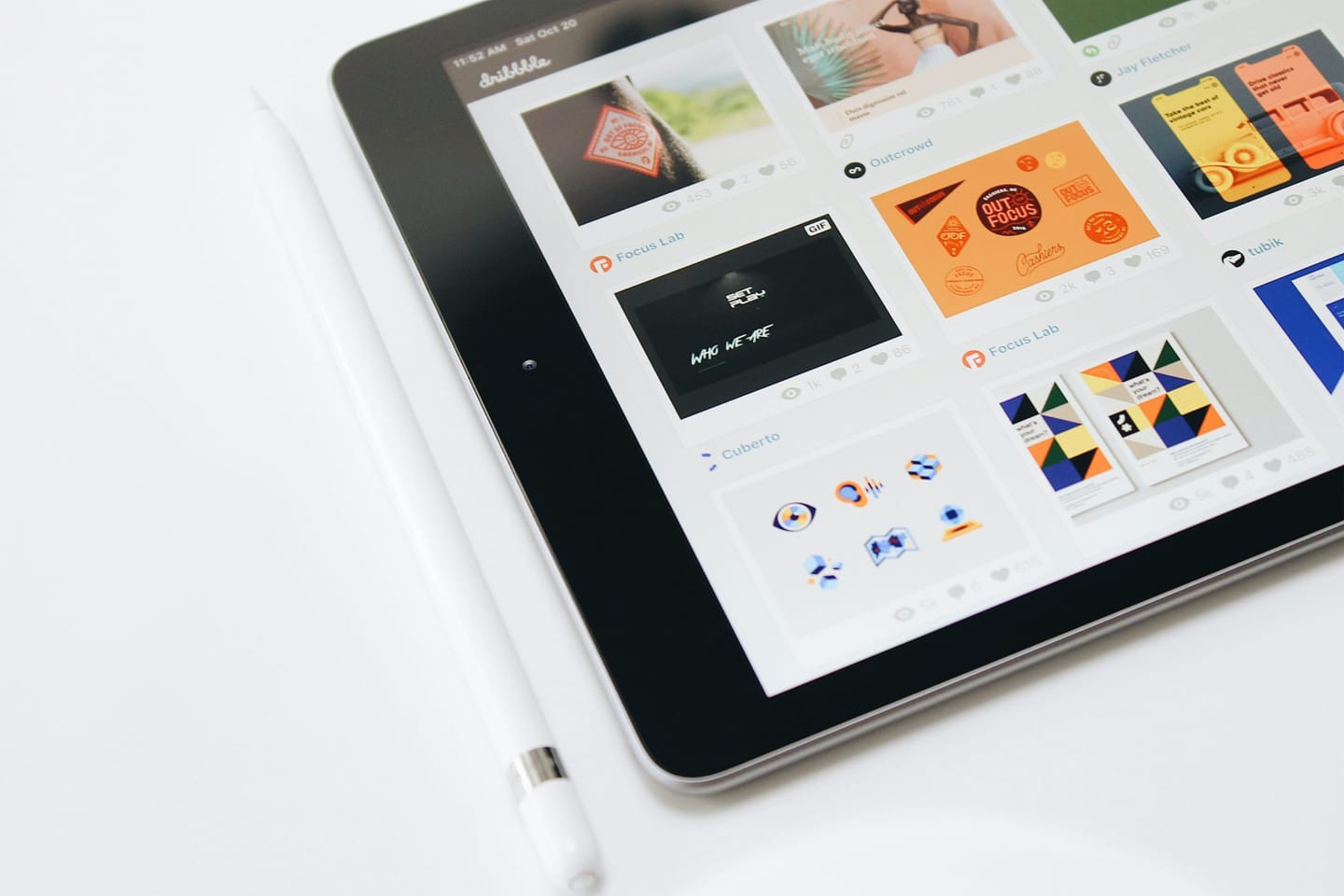 Tablet displaying a gallery of design work, with a stylus beside it on a white surface