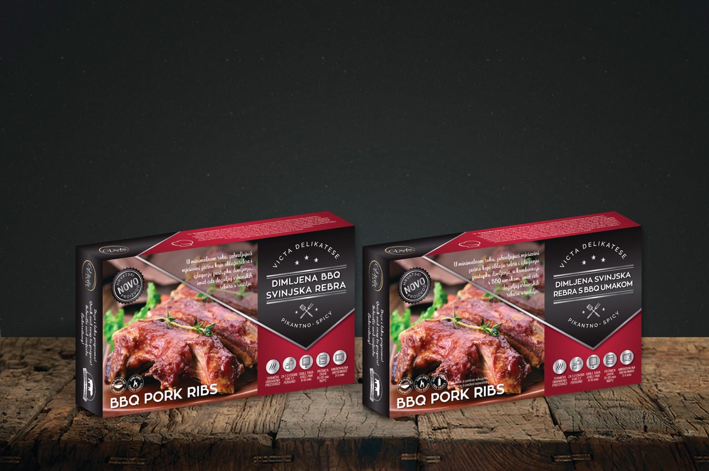 Two Victa Food BBQ Pork Ribs packs in red and dark grey with white lettering, on a wooden surface against a dark grey background
