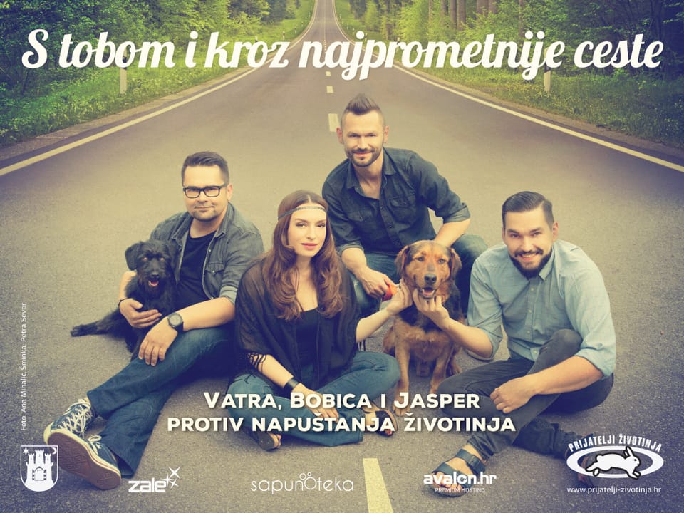 Animal Friends Croatia billboard: the band Vatra, three men and a woman, on a road with a brown and a black dog, slogan “S tobom i kroz najprometnije ceste” (With you, even on the busiest roads)