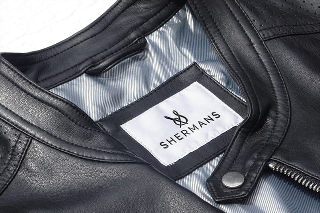 White sewn-in Shermans label on a black leather jacket