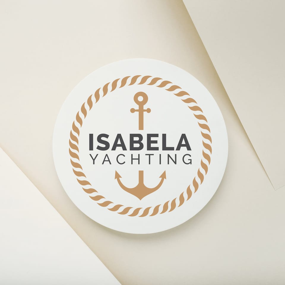 Logo design for Isabela Yachting: the gold logo, a circle of nautical rope with an anchor and the name in the middle, on a beige paper-like background.