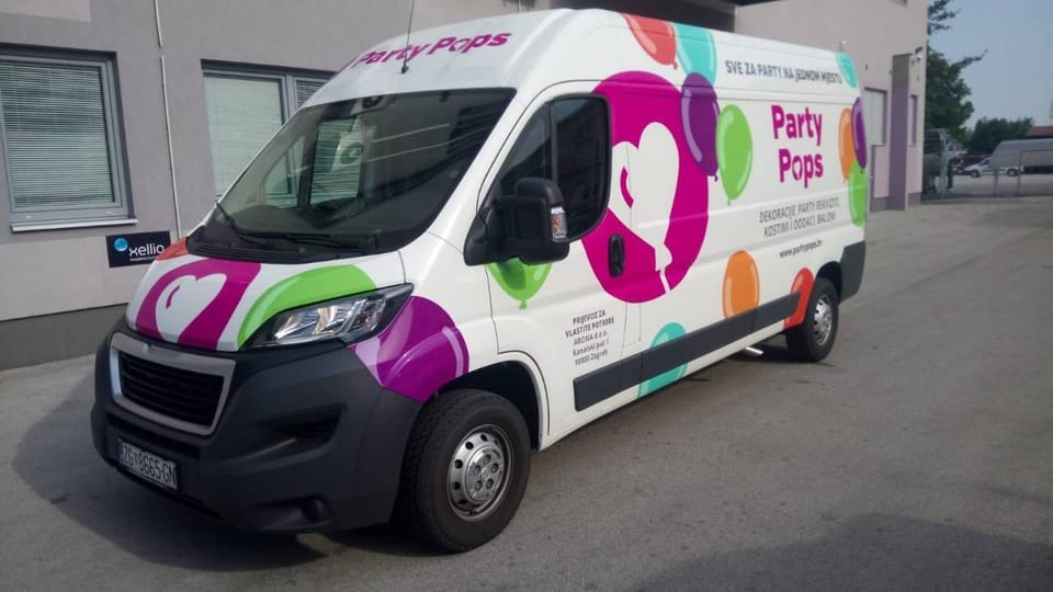 Party Pops van wrap, seen from the front and side: a magenta circle with a white heart-shaped balloon, colourful balloons and the Party Pops name with the slogan and contact details
